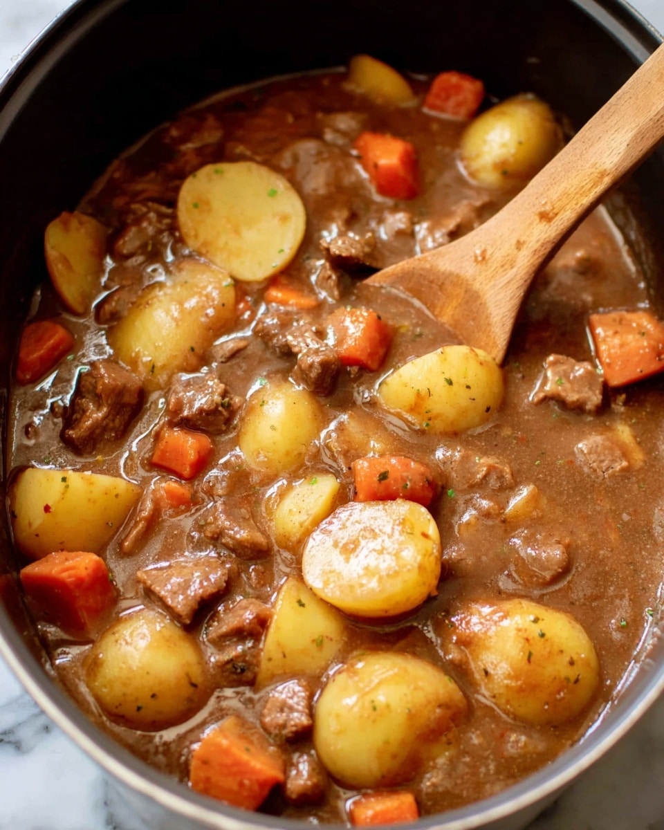 The image shows a close-up of a stew inside a metal pot, with a wooden spoon stirring the mix. The stew has several layers of ingredients: yellow round slices of potatoes scattered throughout, small whole orange baby carrots, and chunks of brown cooked meat mixed in a thick brown gravy. The texture looks soft and hearty, with a glossy sauce coating the ingredients. The edges of the metal pot are slightly visible, and the scene is set against a white marbled texture. The wooden spoon in the stew is partially visible, indicating it is being stirred. photo taken with an iphone --ar 4:5 --v 7