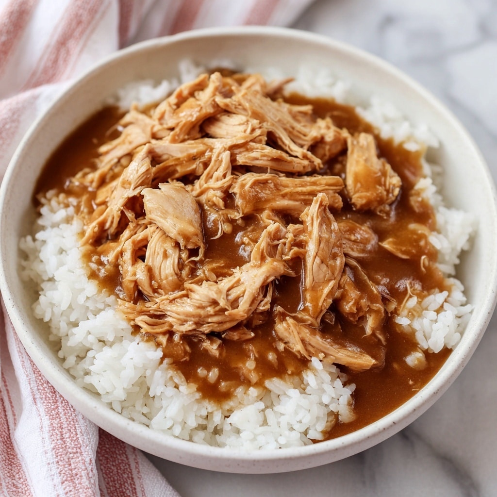 The image shows three large pieces of golden brown fried chicken breasts covered in a thick, glossy, brown gravy. The chicken pieces are partially submerged in the gravy, which has a smooth and slightly shiny texture with small lumps visible. The chicken skin appears crispy and slightly wrinkled, with the gravy coating it unevenly in some places. The background is a close-up of a white marbled textured surface, though the main focus is on the chicken and gravy filling most of the frame. photo taken with an iphone --ar 4:5 --v 7