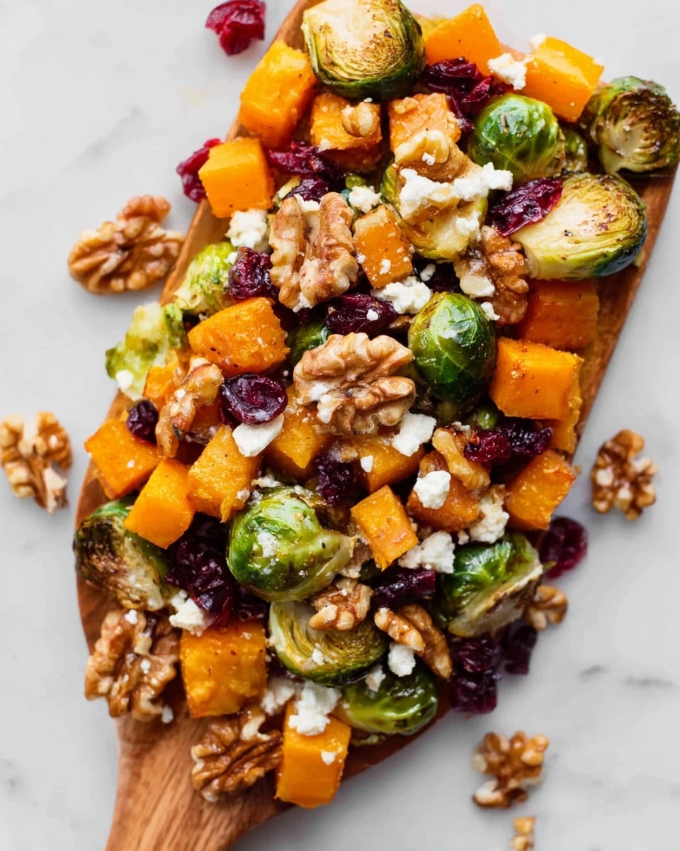 A long, white rectangular plate is filled with a colorful mix of roasted Brussels sprouts, orange cubed butternut squash, and bright red dried cranberries, all scattered evenly. Large, light brown walnut halves are placed on top, adding texture and contrast. The Brussels sprouts are halved and show a slight char with a mix of green and brown hues. The butternut squash cubes are firm and bright orange, while the dried cranberries are small, wrinkled, and shiny. The plate sits on a white marbled surface with a wooden cutting board partially visible on the left side. photo taken with an iphone --ar 4:5 --v 7